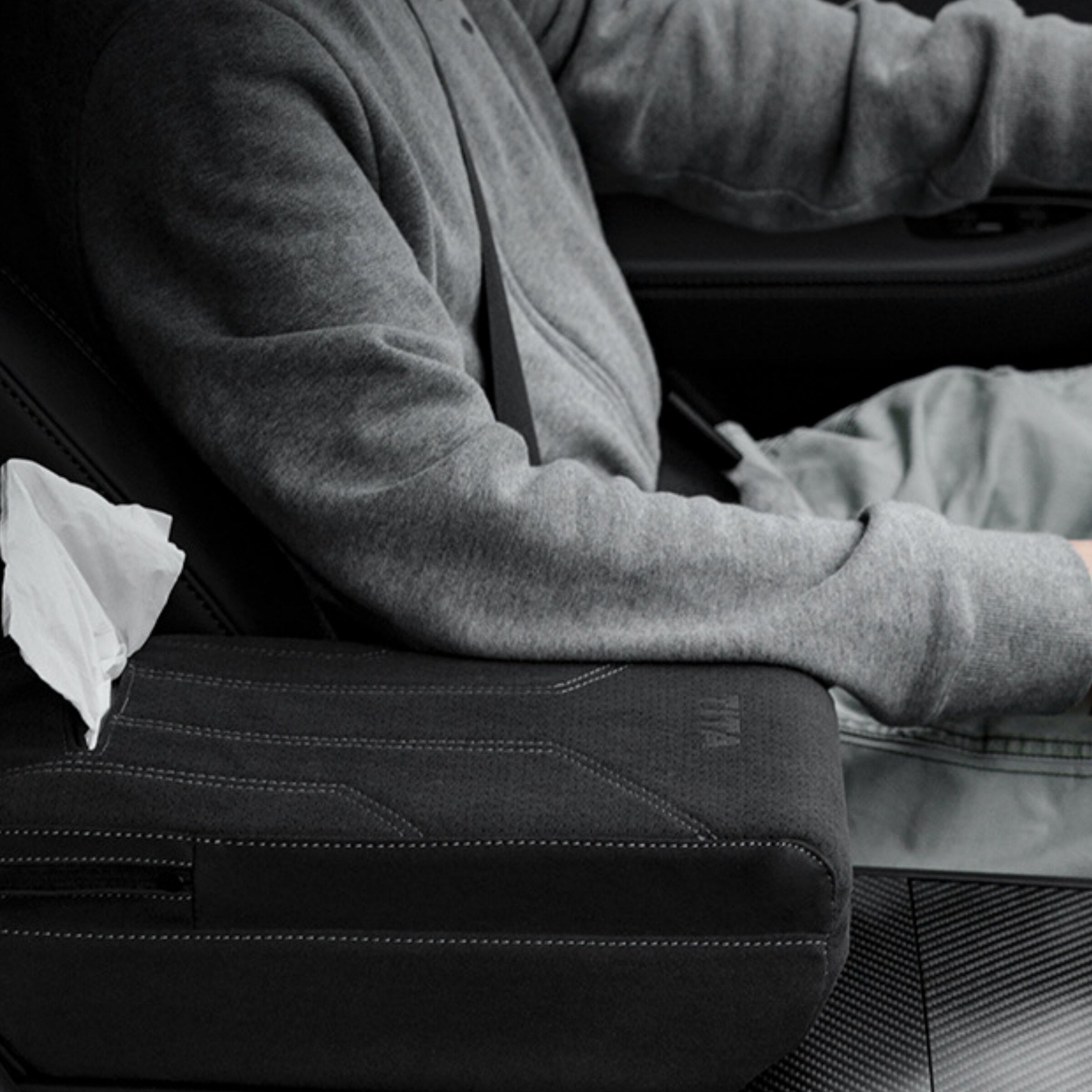 Tesla driver using suede armrest booster pad with tissue box